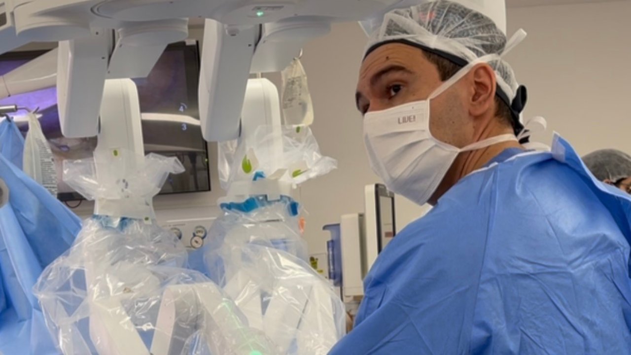 Dr. Fábio Faleiro ao lado do robô cirúrgico durante colecistectomia robótica