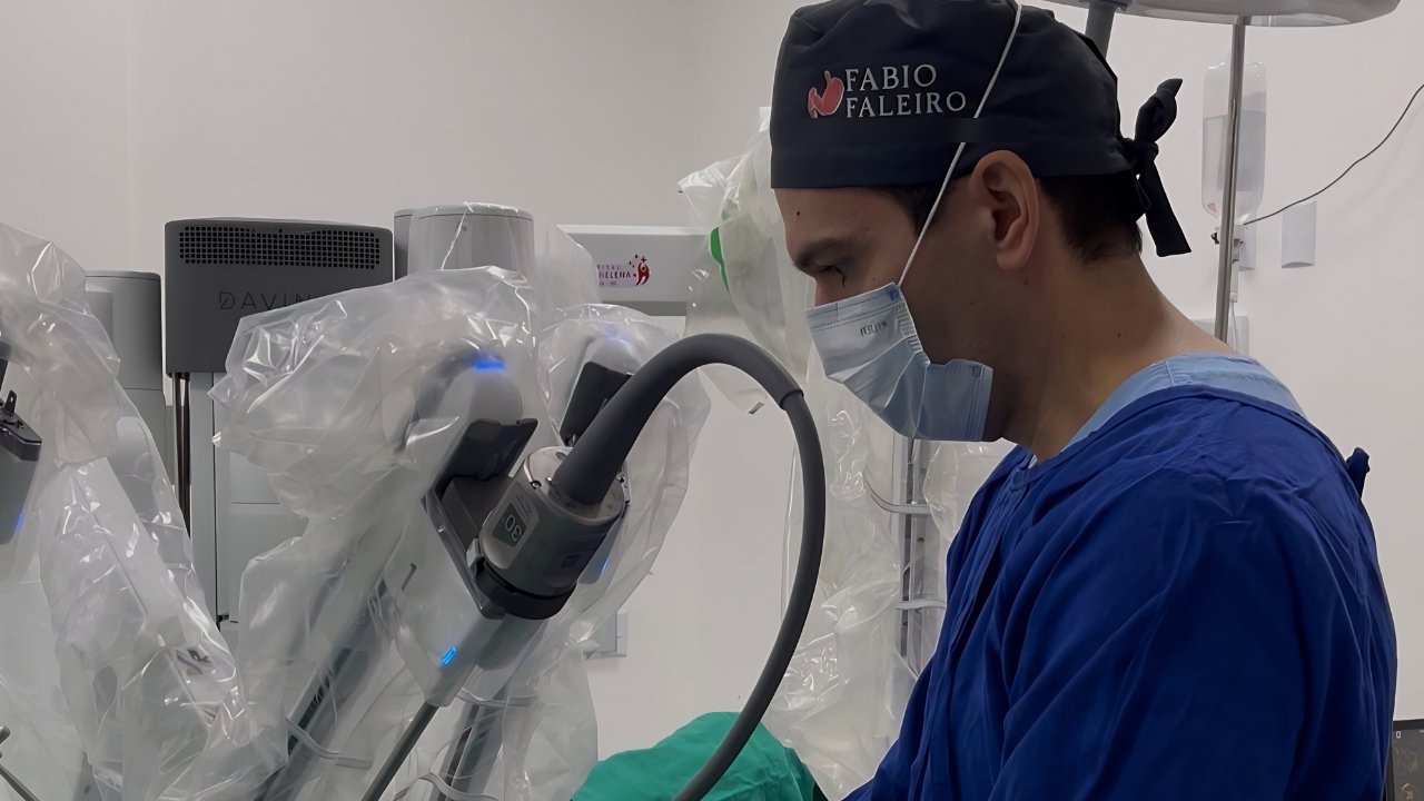 Dr. Fábio Faleiro posicionando a ótica do robô cirúrgico